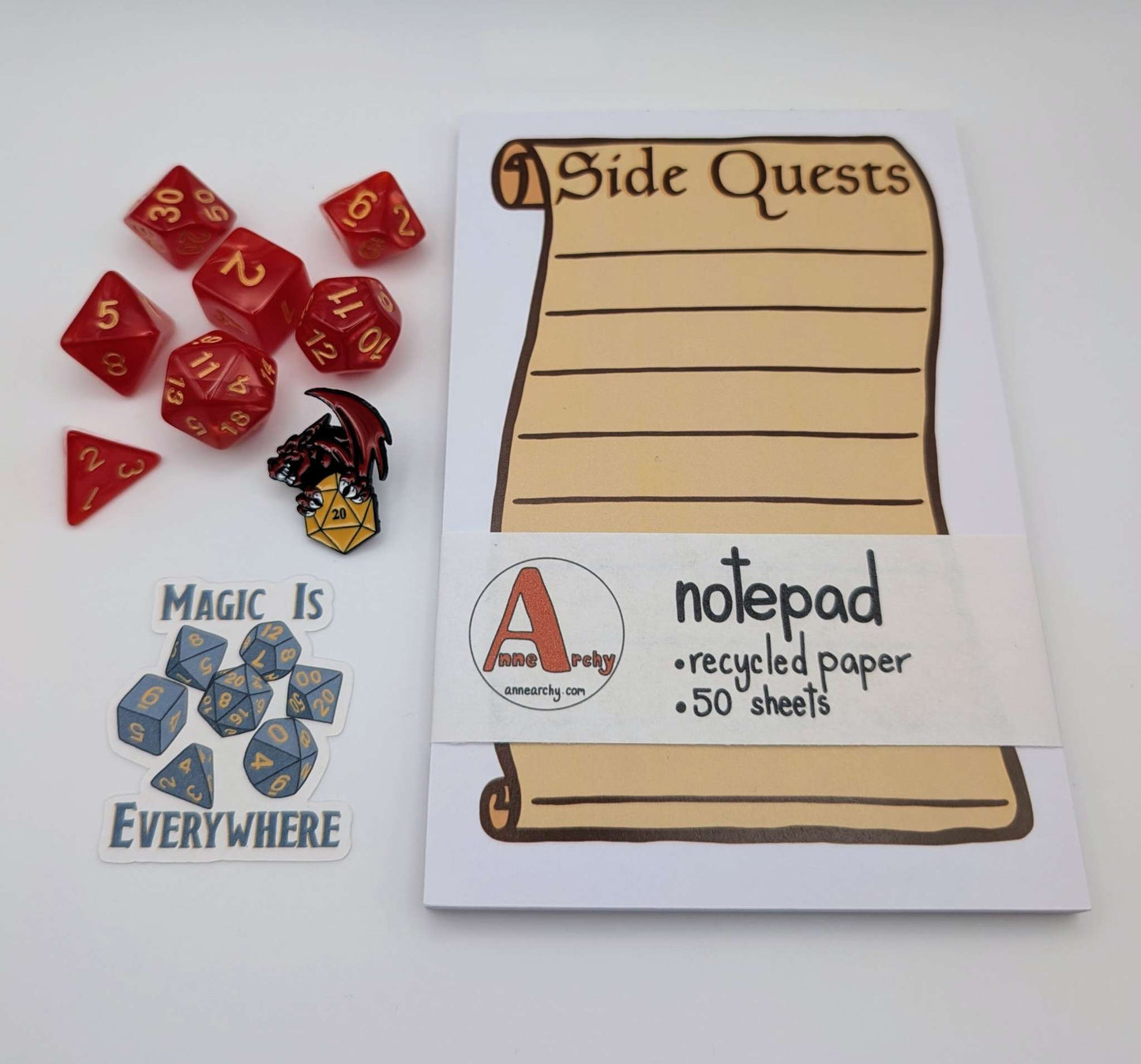 Seven piece dice set, dice sticker, dnd pin, and a notepad that says side quests