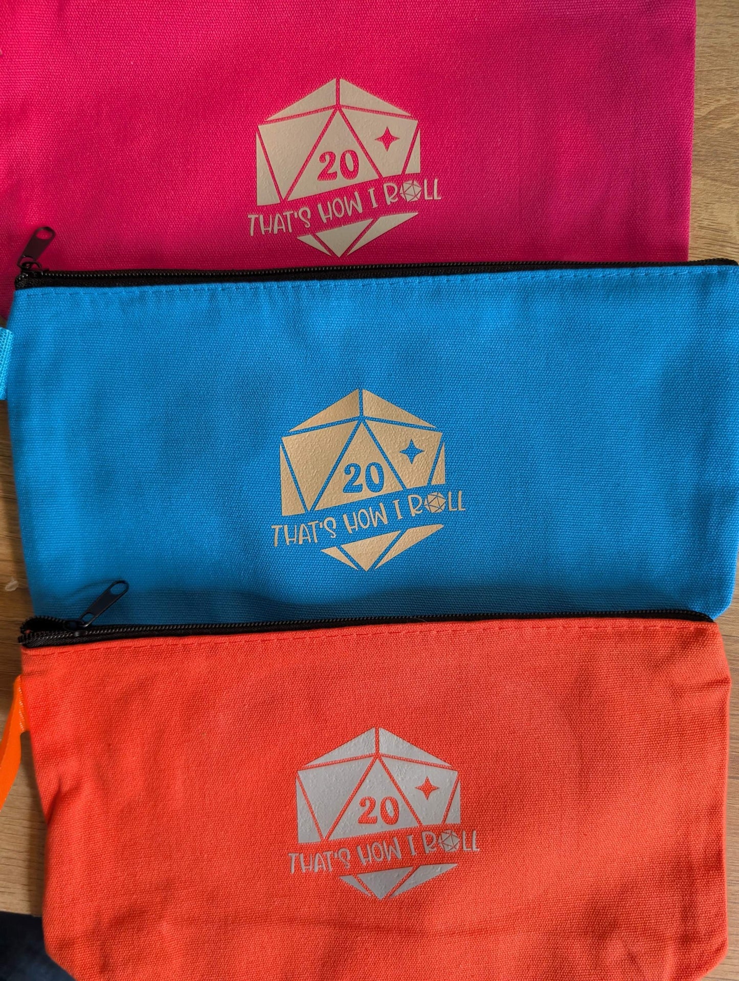 Zippered pouches with a D20 dice and words "that's how I roll"