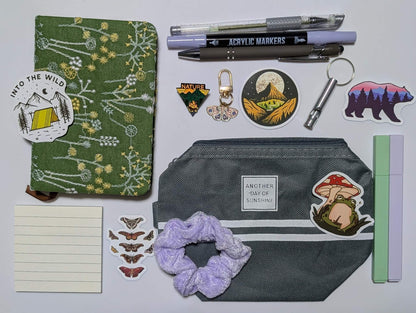 Nature Nerd Basic Bundle with green floral journal, stickers, ballpoint pen, highlighters, gel pen, markers, keychain, sticky notepad, pin, scrunchie, zippered pouch, and whistle keychain