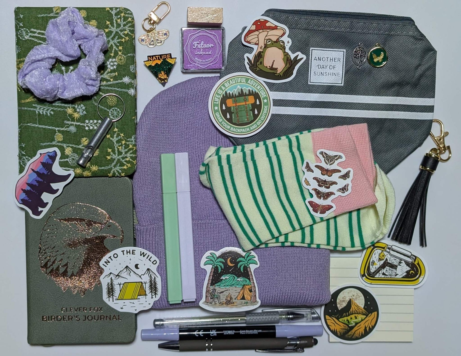 Nature Nerd Legendary Bundle with green floral journal, stickers, ballpoint pen, highlighters, gel pen, markers, keychain, sticky notepad, pin, scrunchie, zippered pouch, and whistle keychain, socks, ink pad, stamp, beanie, charms, birding journal, extra keychain