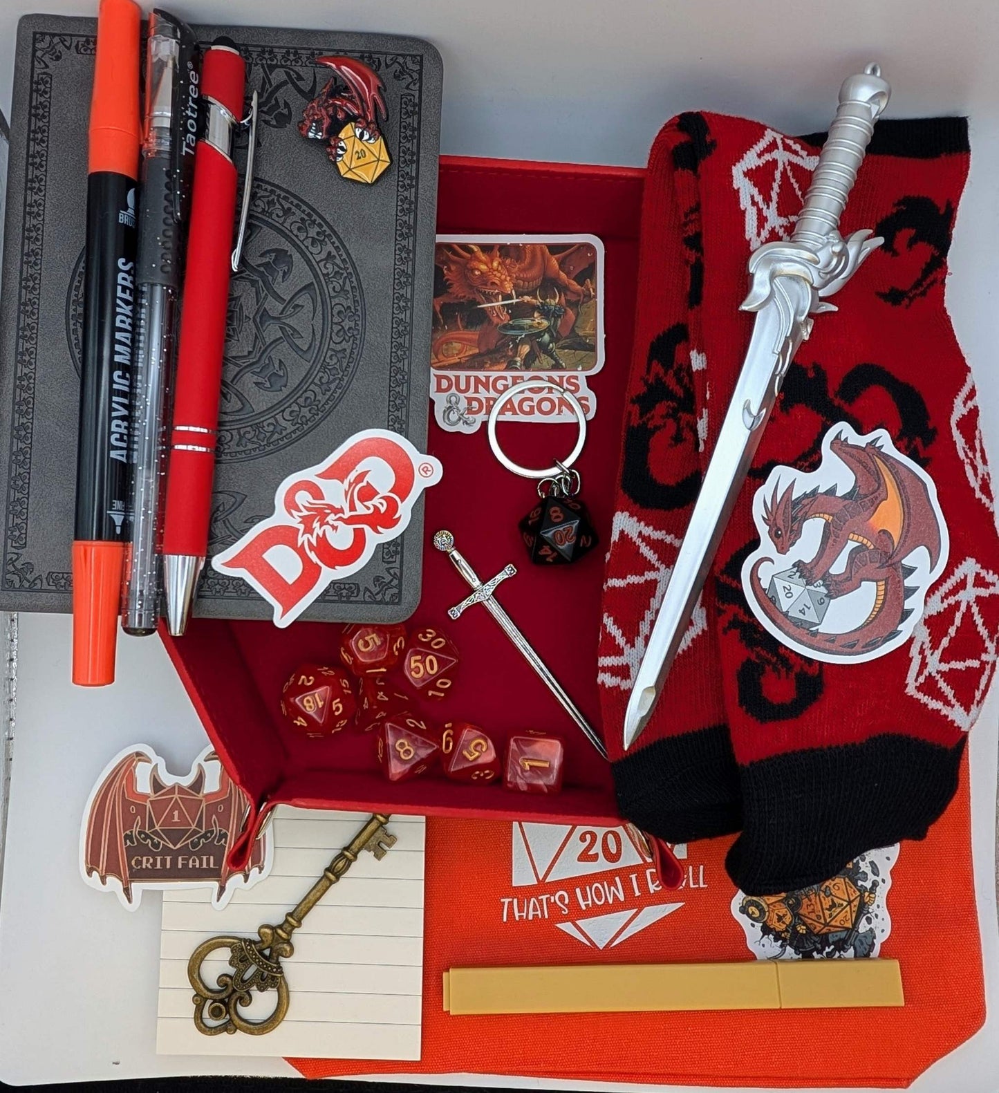 DnD Nerd Deluxe Bundle with dice, socks, faux leather notebook, pens, keychain, stickers, and sword bookmark