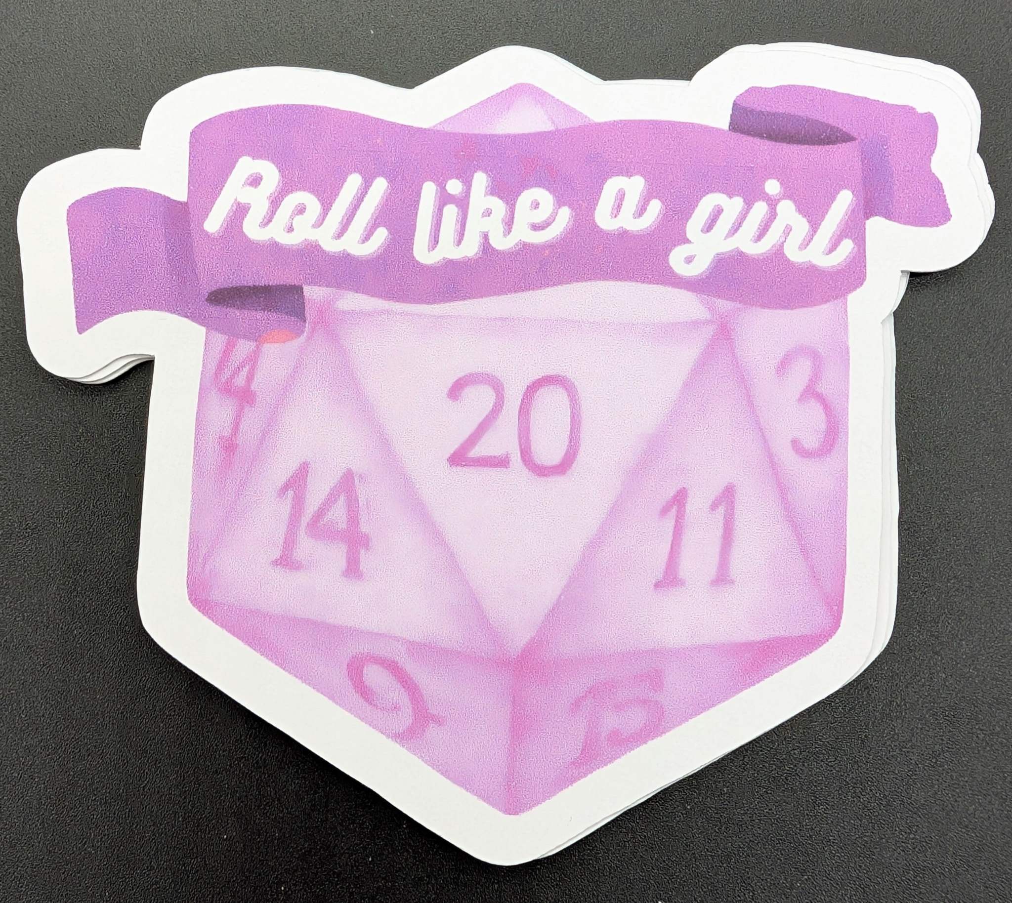 Sticker with D20 dice with a banner reading roll like a girl in purple