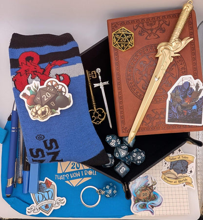 DnD Nerd Deluxe Bundle featuring notebook, dice, socks, pens, keychain, stickers, and sword bookmark