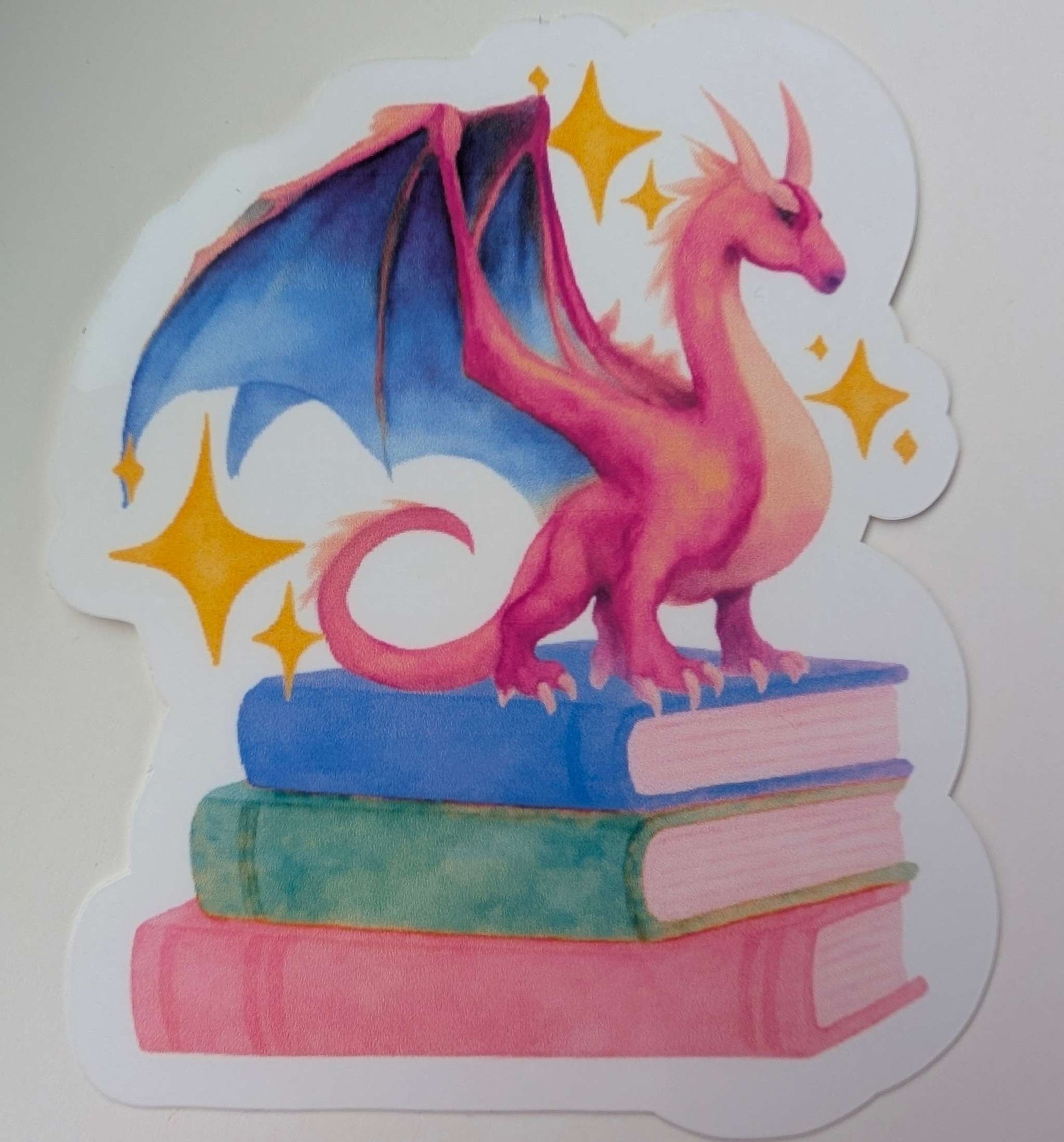 sticker of dragon on a stack of books