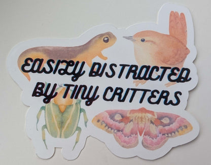 sticker with a moth, newt, beetle, and bird that says easily distracted by tiny critters