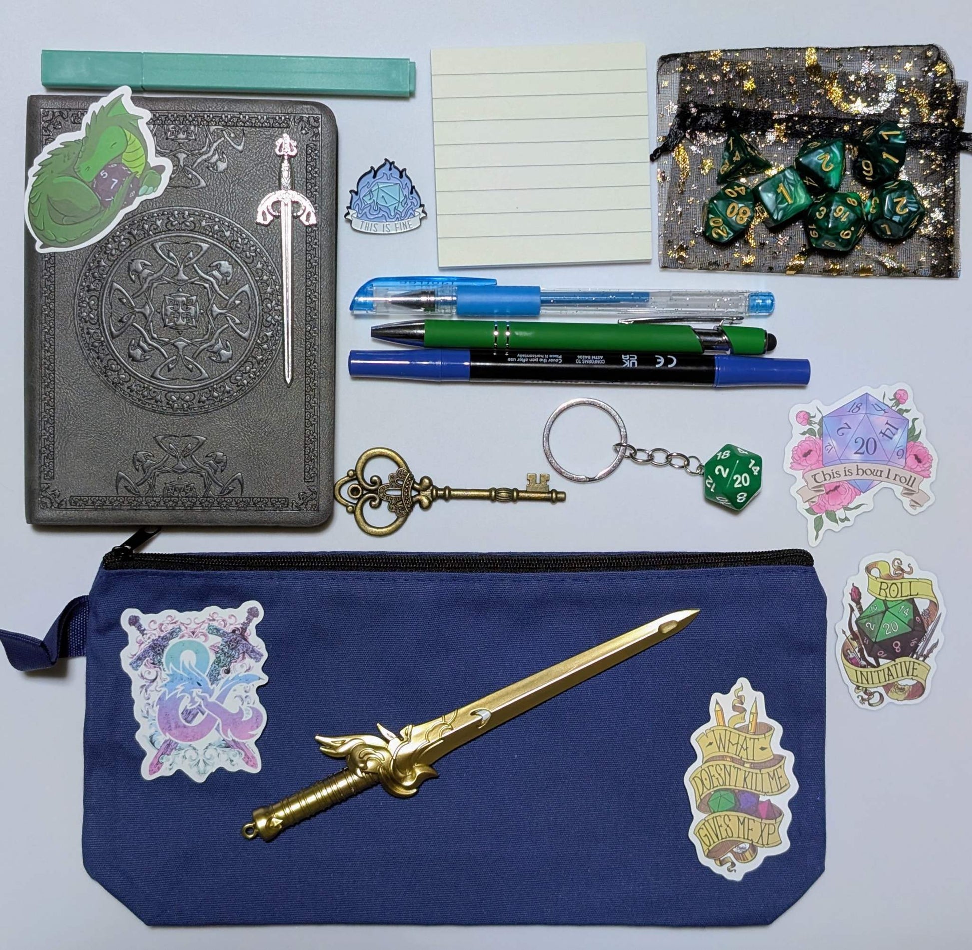 DnD nerd basic bundle with a vintage style notebook, ballpoint pen, gel pen, highlighter, marker, sticky notepad, D20 keychain, sword pen, zippered pouch, pin, stickers, key, sword bookmark, and dice set