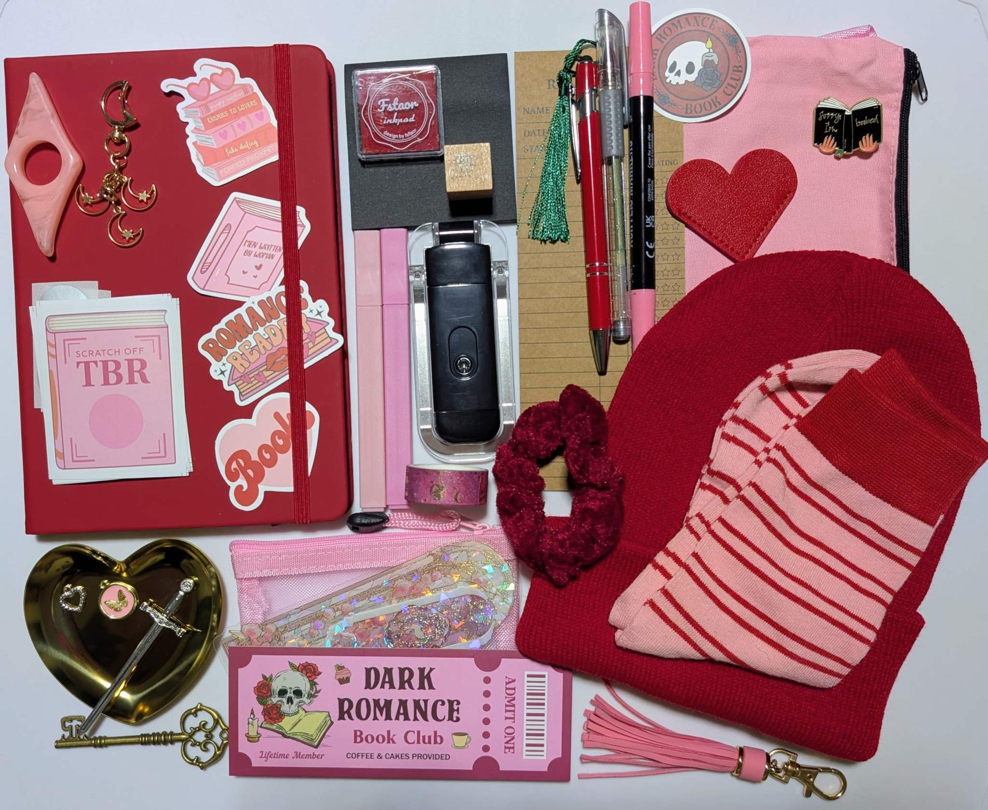 Book nerd legendary bundle with journal, book light, socks, stamp, ink pad, TBR scratchers, stickers, keychain, bookmarks, zippered pouch, highlighters, gel pen, ballpoint pen, marker, page holder, sticky notepad, pin, scrunchie, beanie, trinket dish, keychain, metal feather bookmark, washi tape, key, charms, sword bookmark, mesh pouch