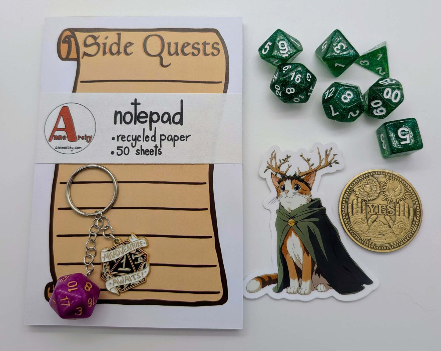 A side quest notepad, DnD inspired keychain, dnd class cat sticker, yes/no decision coin, and a dice set