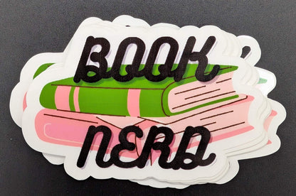 Sticker with a green and pink book and text that says book nerd