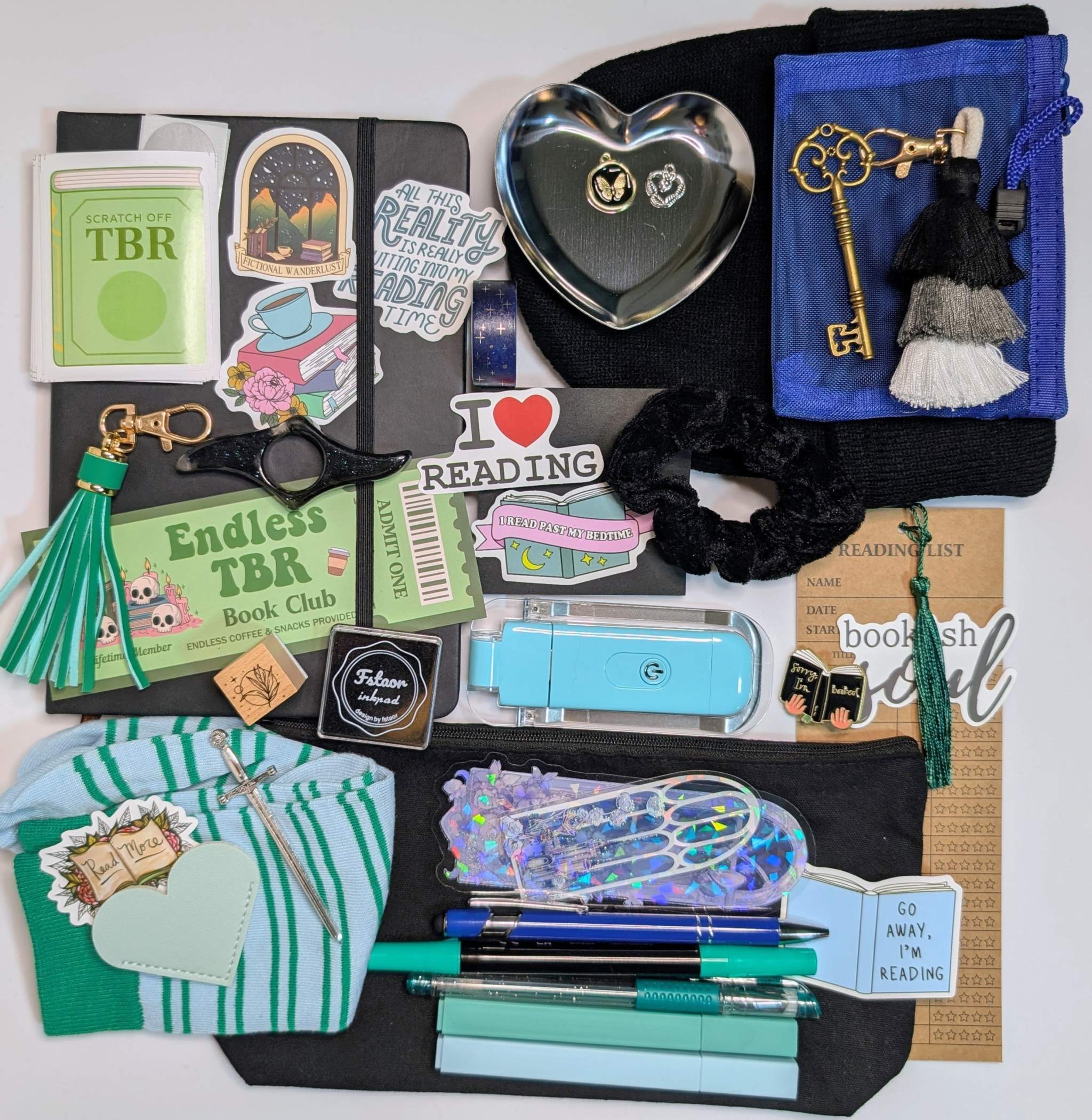 Book nerd legendary bundle with journal, book light, socks, stamp, ink pad, TBR scratchers, stickers, keychain, bookmarks, zippered pouch, highlighters, gel pen, ballpoint pen, marker, page holder, sticky notepad, pin, scrunchie, beanie, trinket dish, keychain, metal feather bookmark, washi tape, key, charms, sword bookmark, mesh pouch