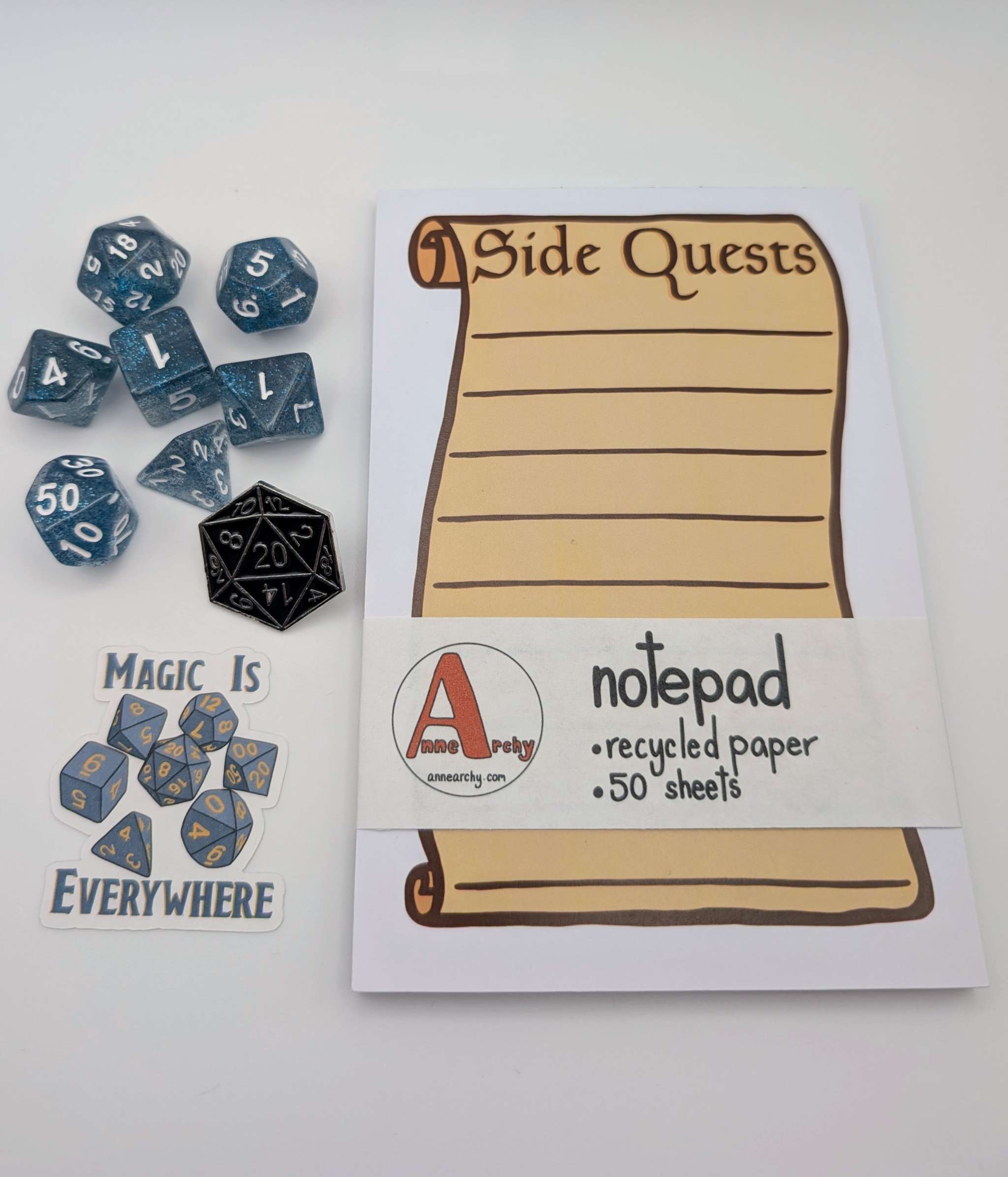 Seven piece dice set, dice sticker, dnd pin, and a notepad that says side quests