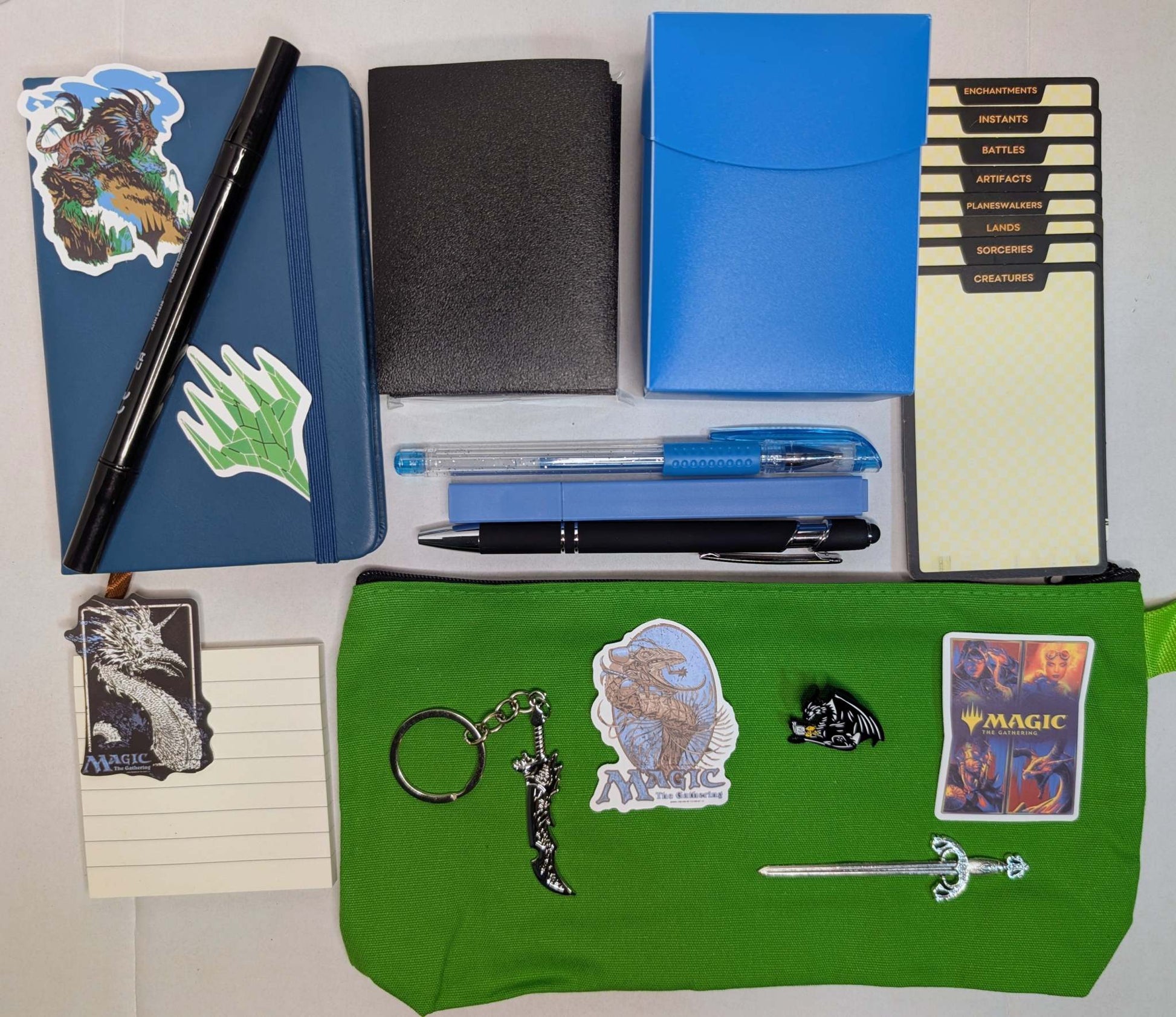 Magic nerd basic bundle wth notebook, ballpoint pen, gel pen, marker, highlighter, sticky notepad, sword keychain, zippered pouch, pin, stickers, sword bookmark, card sleeves, deck dividers, and plastic deck box