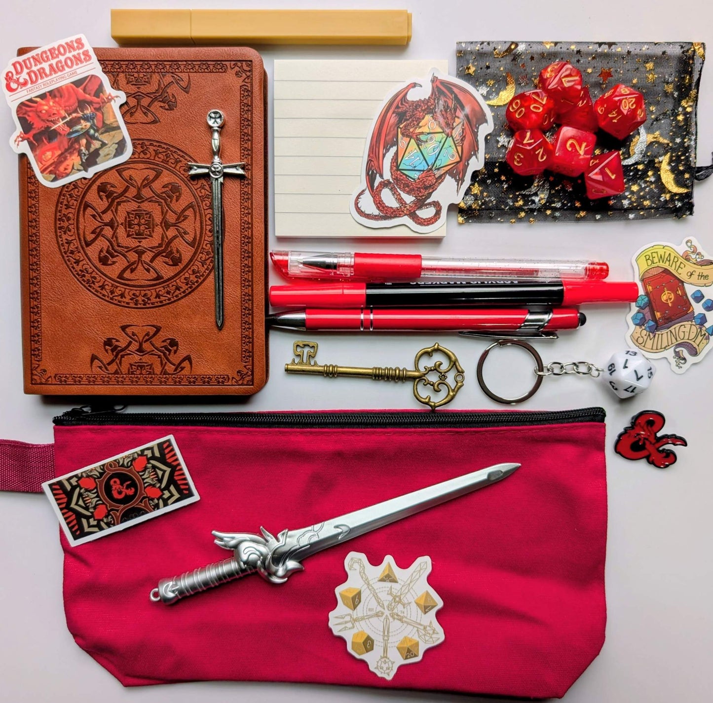 DnD nerd basic bundle with a vintage style notebook, ballpoint pen, gel pen, highlighter, marker, sticky notepad, D20 keychain, sword pen, zippered pouch, pin, stickers, key, sword bookmark, and dice set
